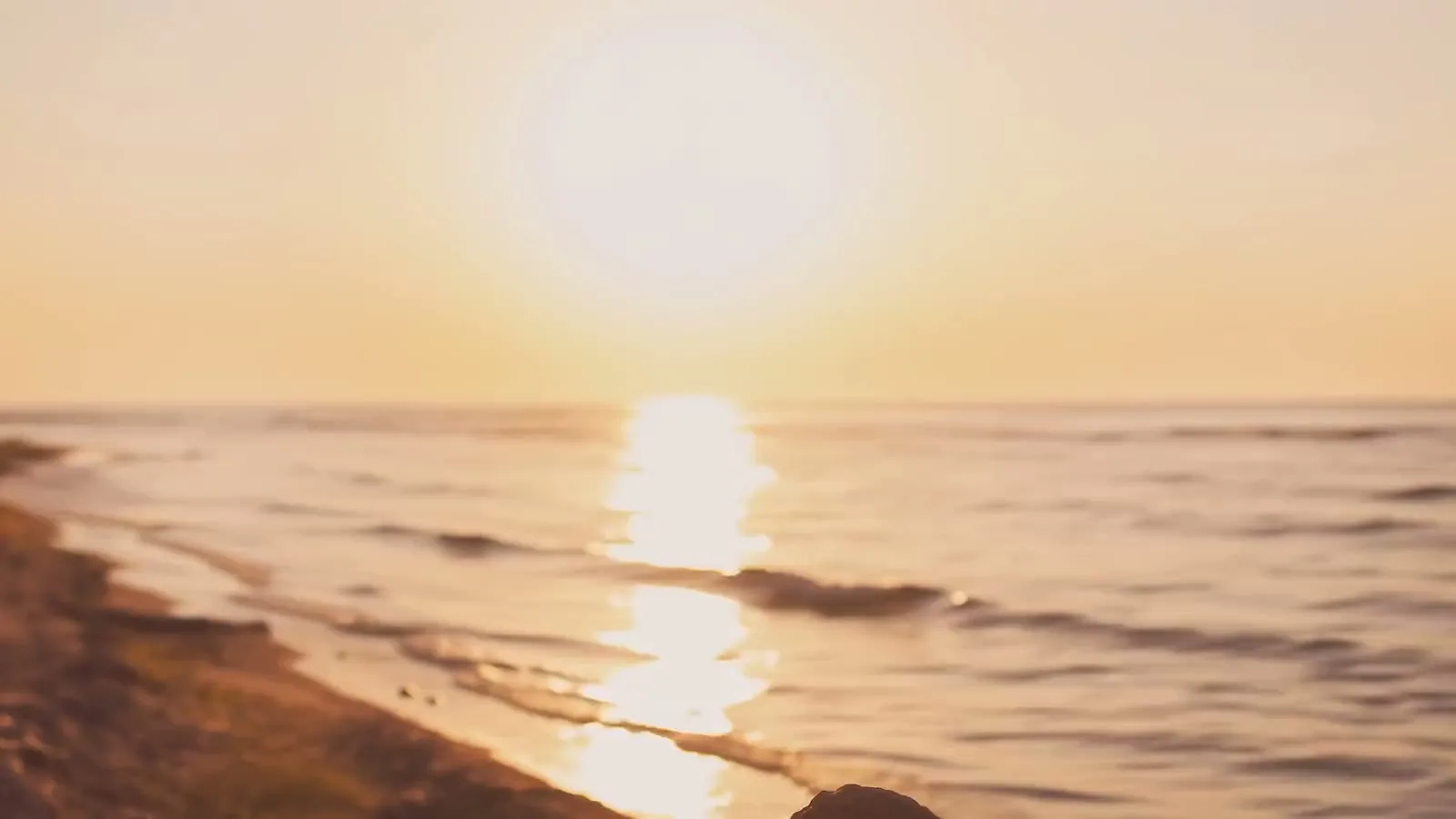 Golden sunset over the ocean, with sunlight sparkling on the water.